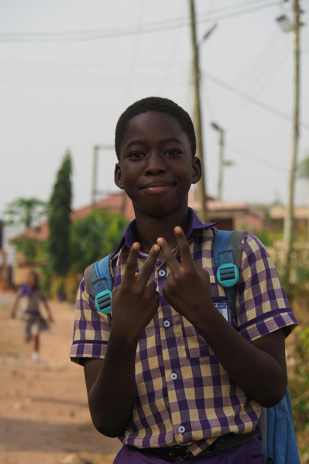 A schoolboy in uniform with his school bag