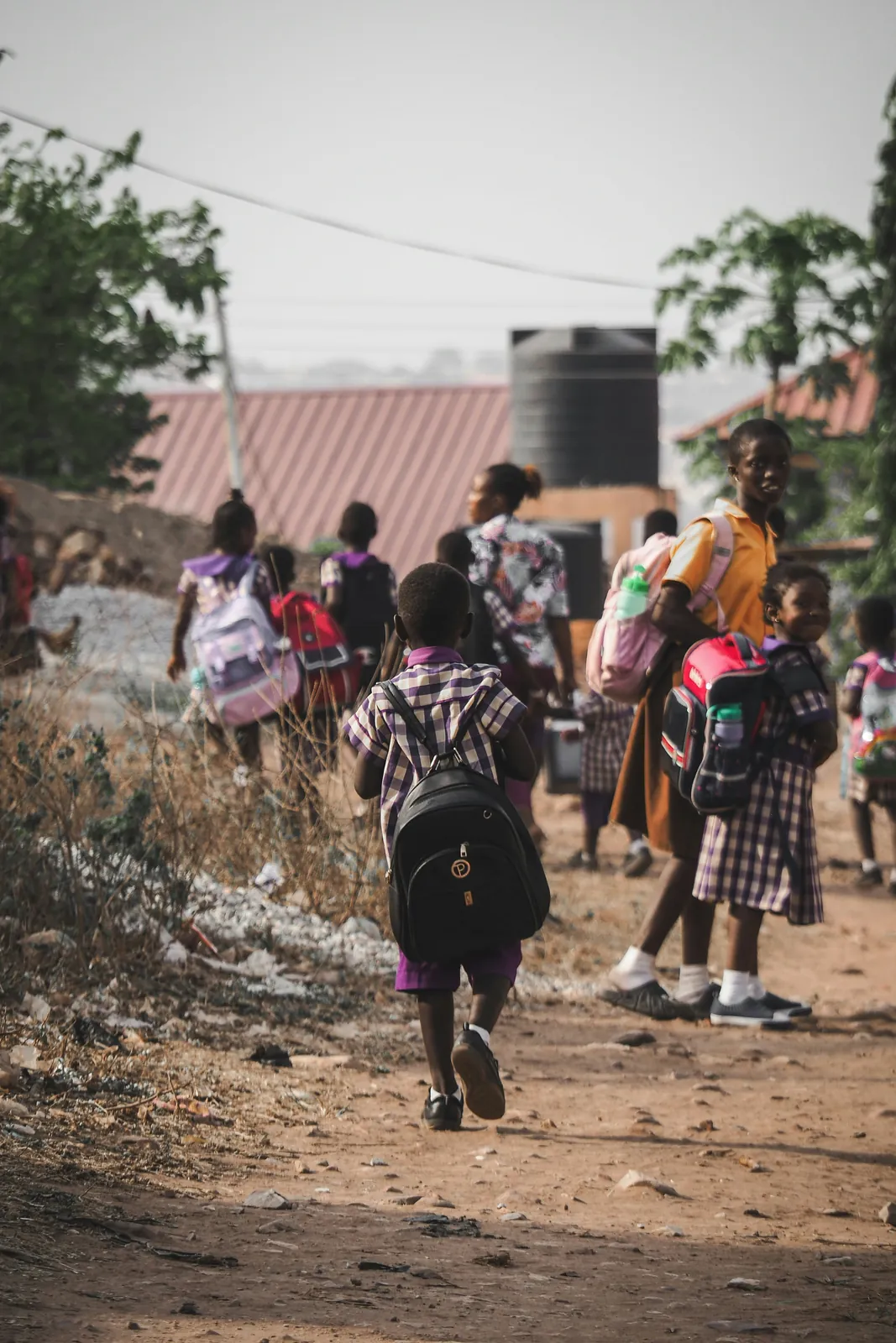 A child walking to school along a dirt path